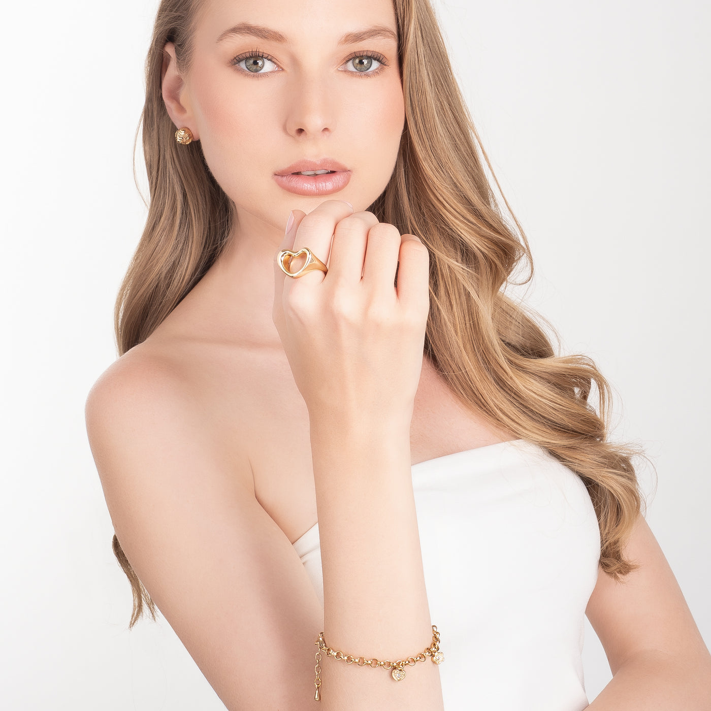 Aretes botón bañados en oro, diseño esférico y grabado